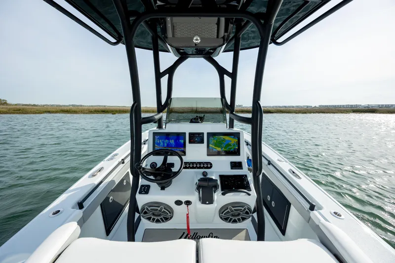 Slide: The Image of 2025 Yellowfin 26 Hybrid boat dashboard with advanced navigation systems on open water. - 14