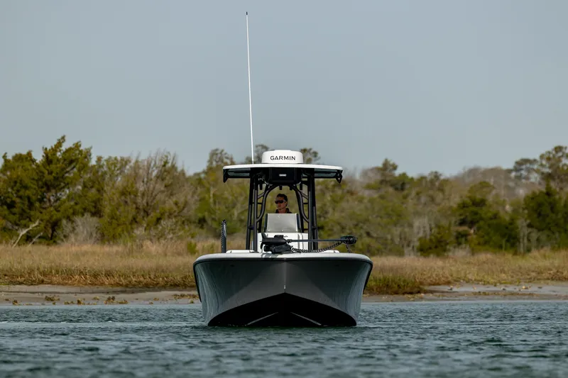 Slide: The Image of 2025 Yellowfin 26 Hybrid boat on water, front view, with trees in the background. - 4