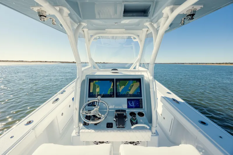 Slide: The Image of 2025 Yellowfin 32 boat dashboard with dual navigation screens on open water. - 18