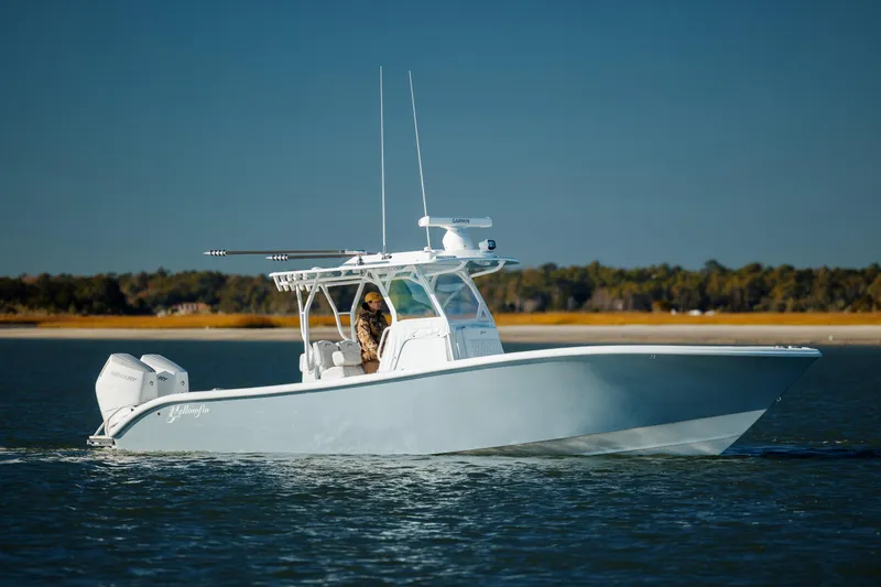 Slide: The Image of 2025 Yellowfin 32 boat cruising on calm water with scenic background. - 3