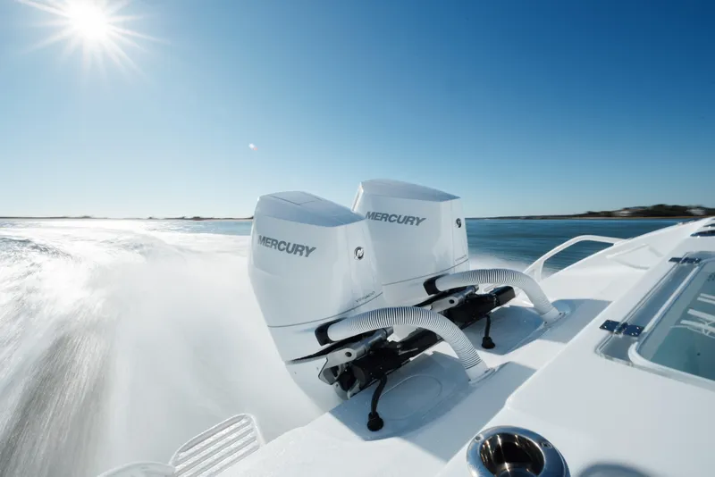Slide: The Image of 2025 Yellowfin 32 boat with dual Mercury engines speeding on open water. - 35