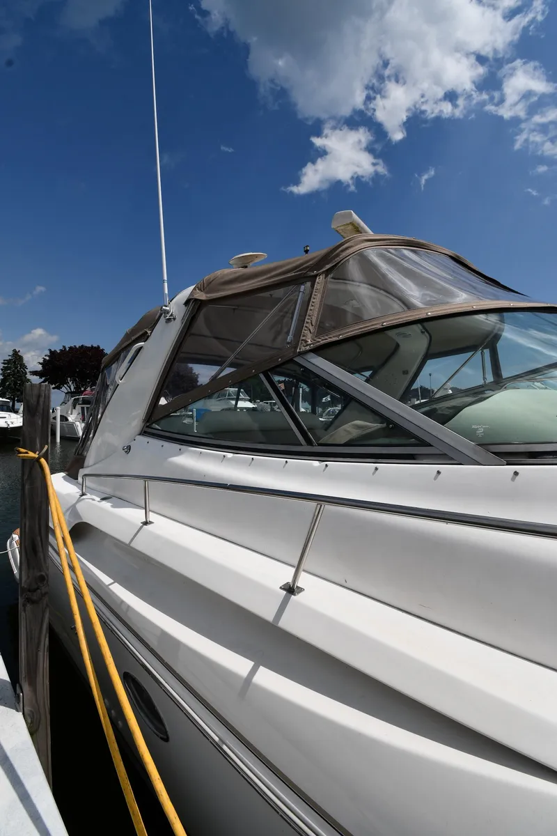 Slide: The Image of 1998 Cruisers Yachts 3870 Express docked under a clear blue sky. - 1