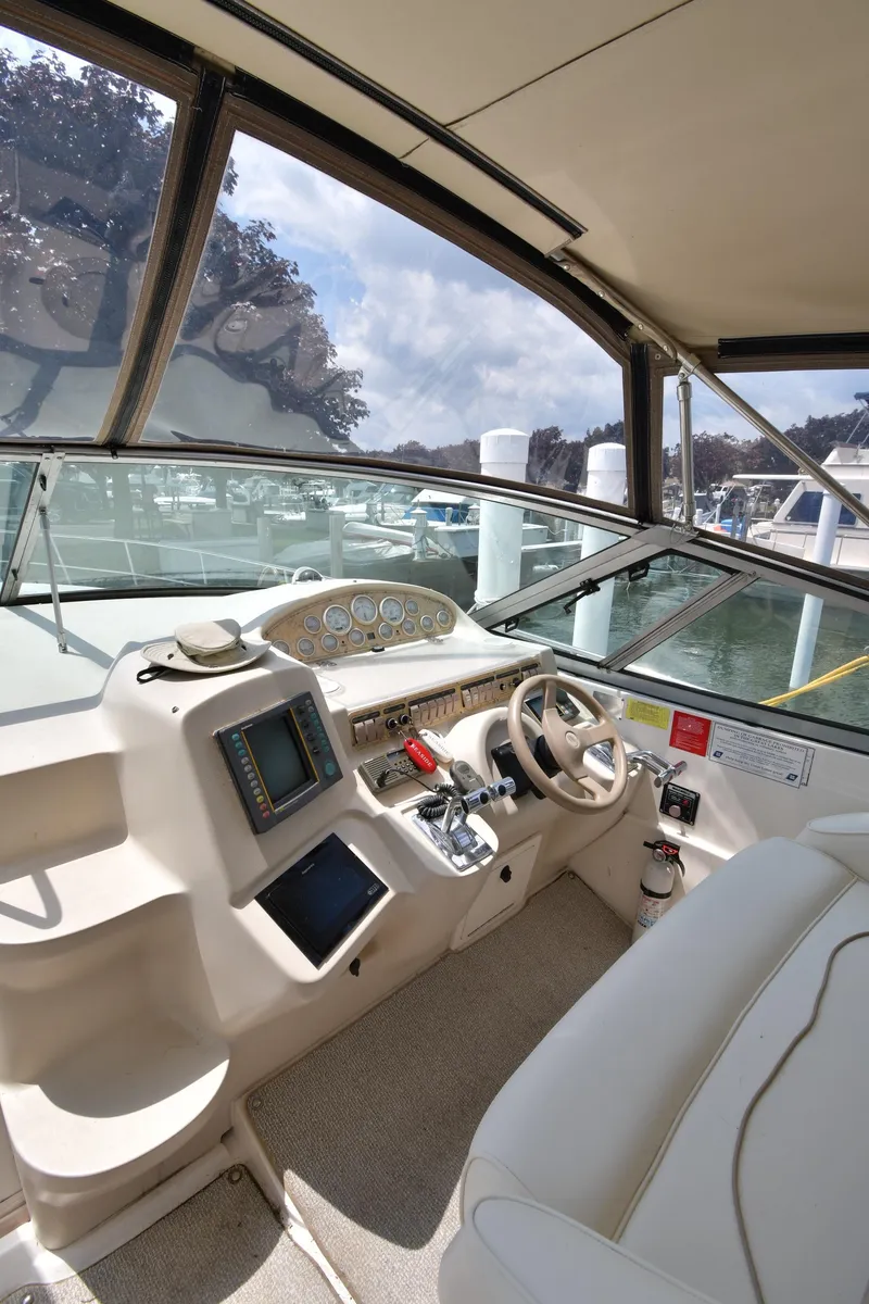 Slide: The Image of 1998 Cruisers Yachts 3870 Express helm with modern navigation equipment and comfortable seating. - 10