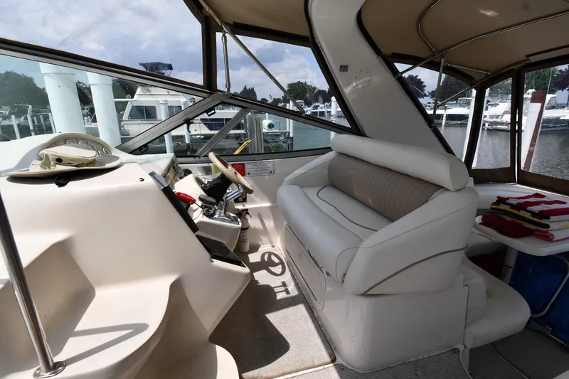 Slide: The Image of 1998 Cruisers Yachts 3870 Express cockpit with helm, seating, and marina view. - 11