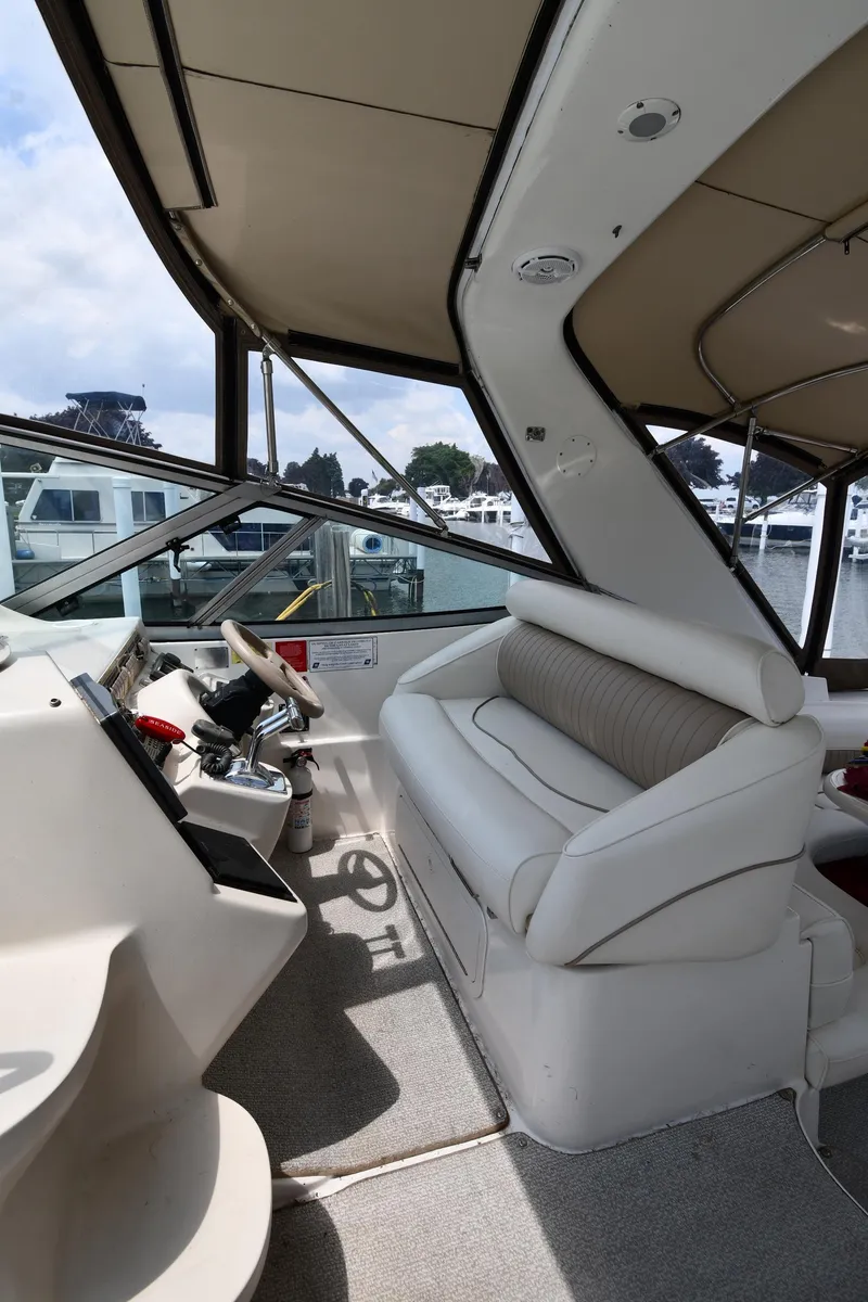 Slide: The Image of 1998 Cruisers Yachts 3870 Express helm station with seating and controls. - 12