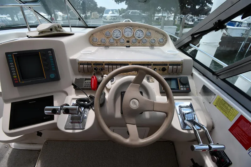 Slide: The Image of 1998 Cruisers Yachts 3870 Express helm with steering wheel and control panel. - 13