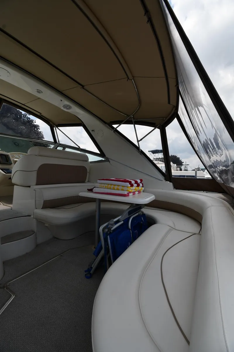 Slide: The Image of 1998 Cruisers Yachts 3870 Express interior seating area with table and cushions. - 18