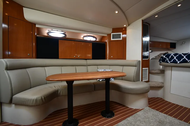 Slide: The Image of Luxurious interior of 1998 Cruisers Yachts 3870 Express with curved seating and wooden table. - 36