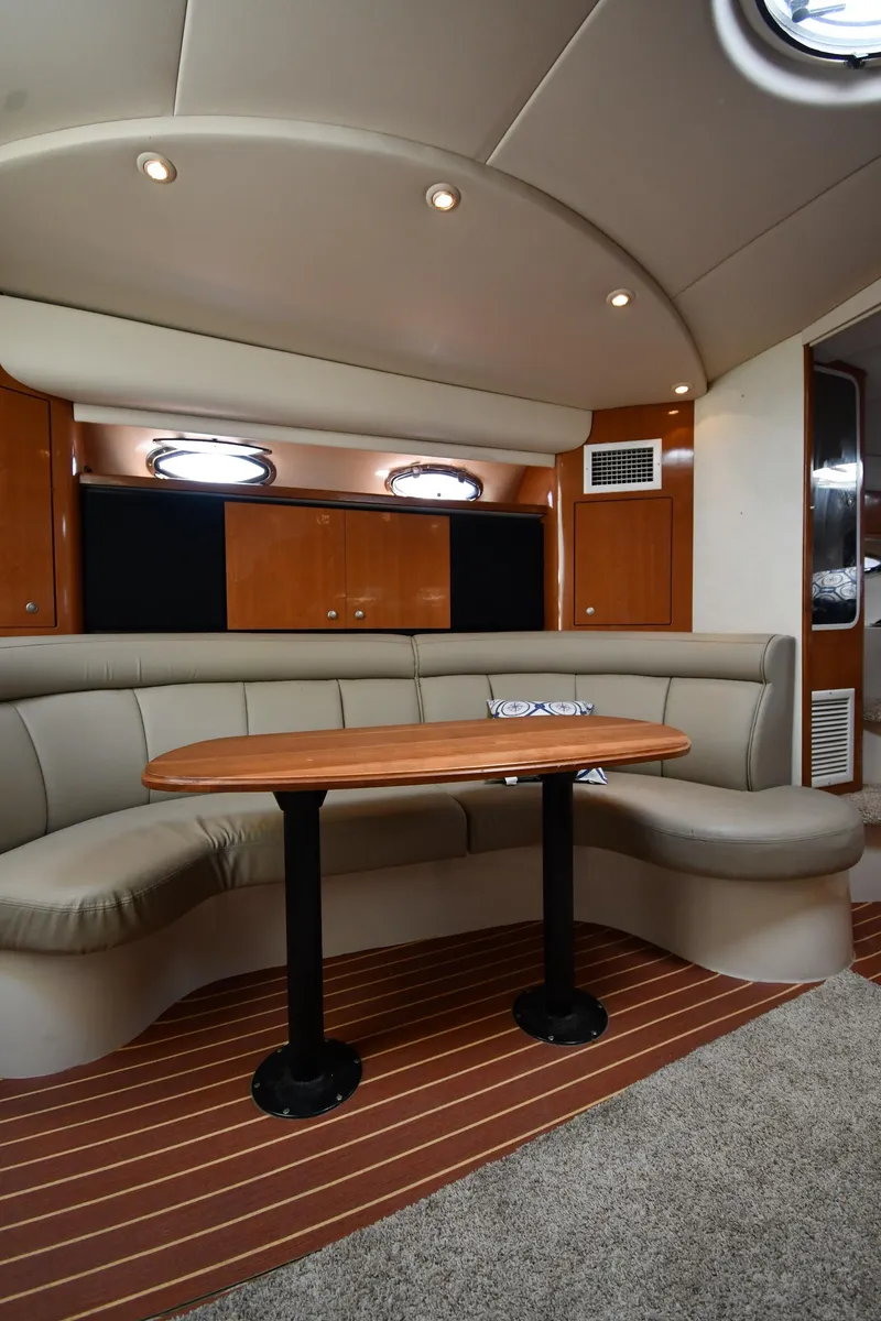 Slide: The Image of 1998 Cruisers Yachts 3870 Express interior with curved seating and wooden table. - 37