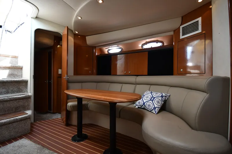 Slide: The Image of 1998 Cruisers Yachts 3870 Express interior with curved seating and wooden table. - 38