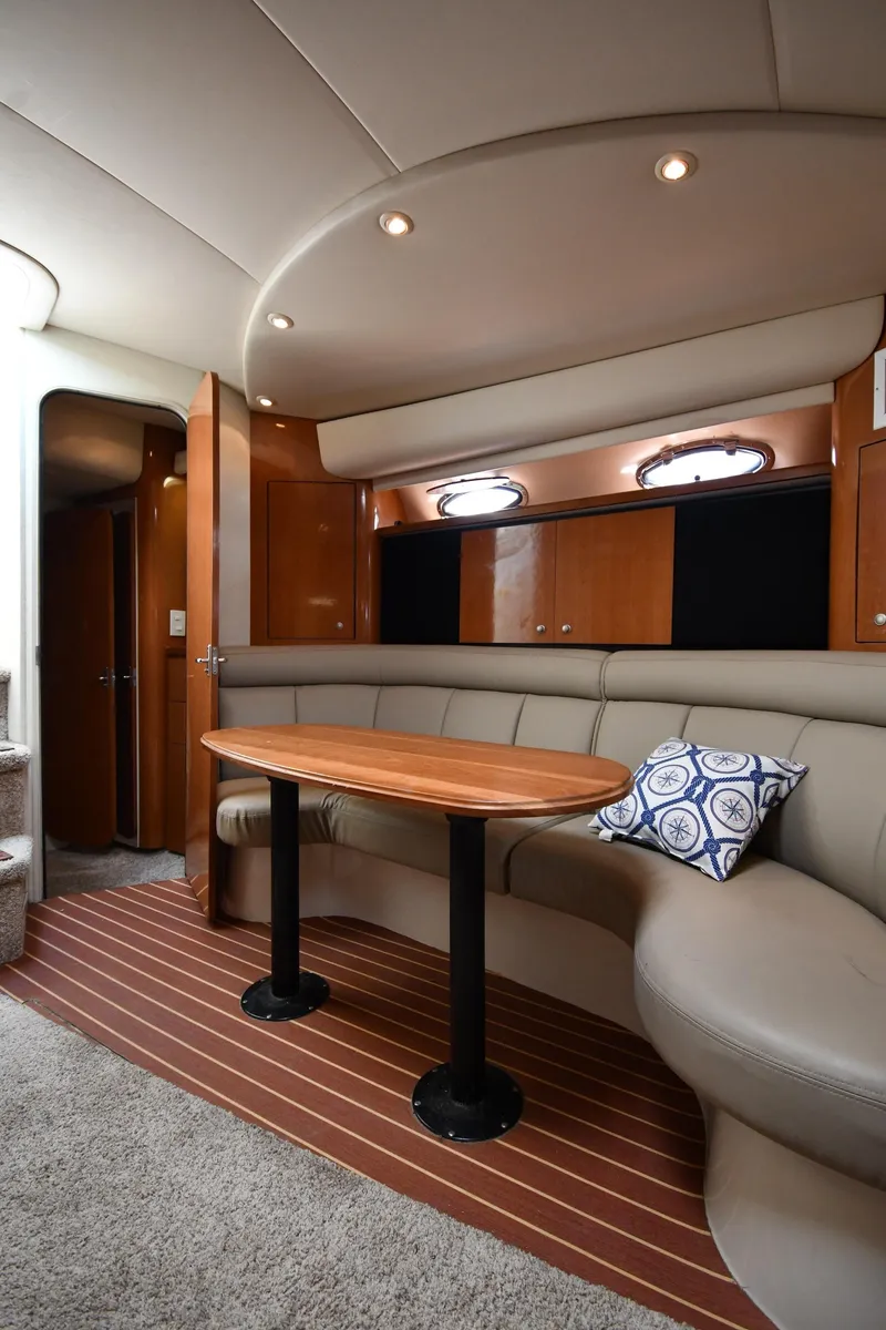 Slide: The Image of 1998 Cruisers Yachts 3870 Express interior with curved seating and wooden table. - 39