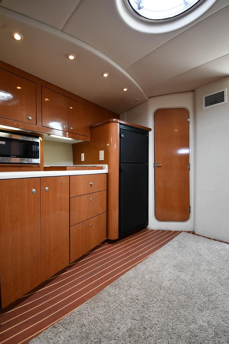 Slide: The Image of 1998 Cruisers Yachts 3870 Express interior kitchen with wood cabinets and modern appliances. - 41