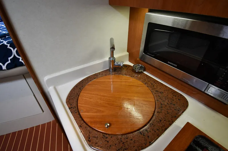 Slide: The Image of 1998 Cruisers Yachts 3870 Express kitchen sink and microwave area. - 45