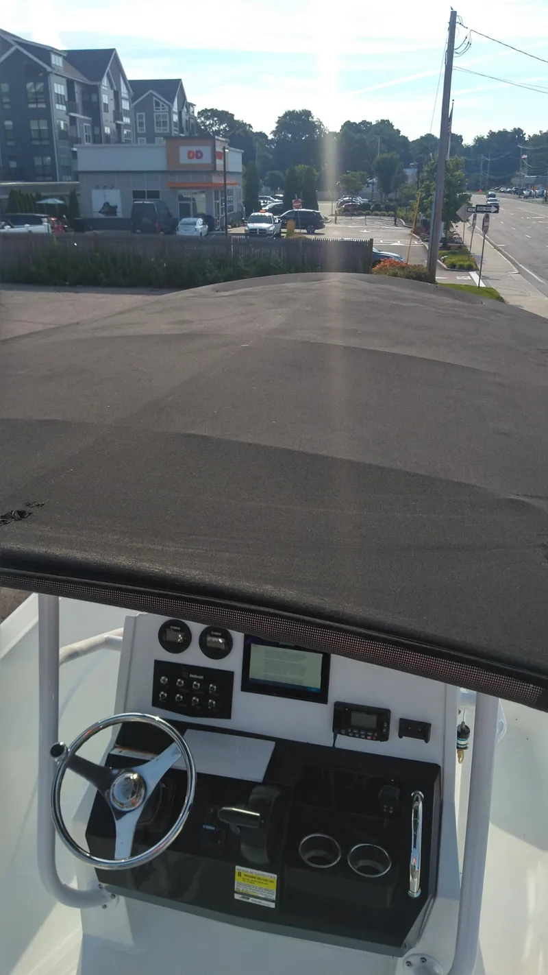 Slide: The Image of Wellcraft 202 Fisherman 2021 boat dashboard and steering wheel, parked near buildings. - 26