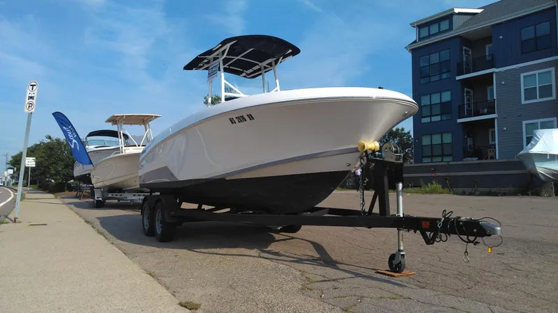 Slide: The Image of 2021 Wellcraft 202 Fisherman boat on a trailer, parked near modern buildings. - 34