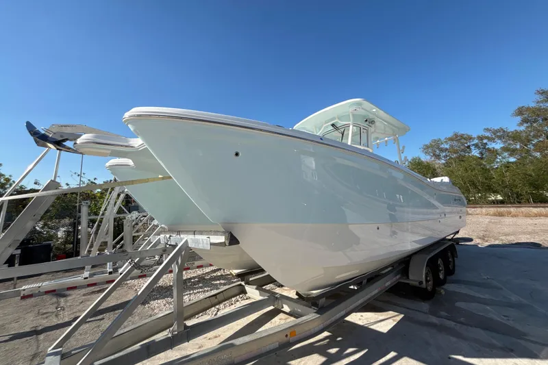 The Image of 2026 World Cat 295 CC boat on trailer under clear blue sky. - 0