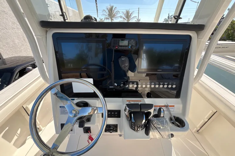 Slide: The Image of 2026 World Cat 295 CC boat dashboard with dual screens and steering wheel. - 6