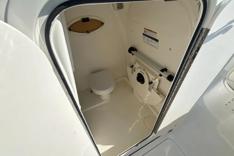 Slide: The Image of Interior of 2026 World Cat 295 CC boat, featuring a compact marine toilet. - 7