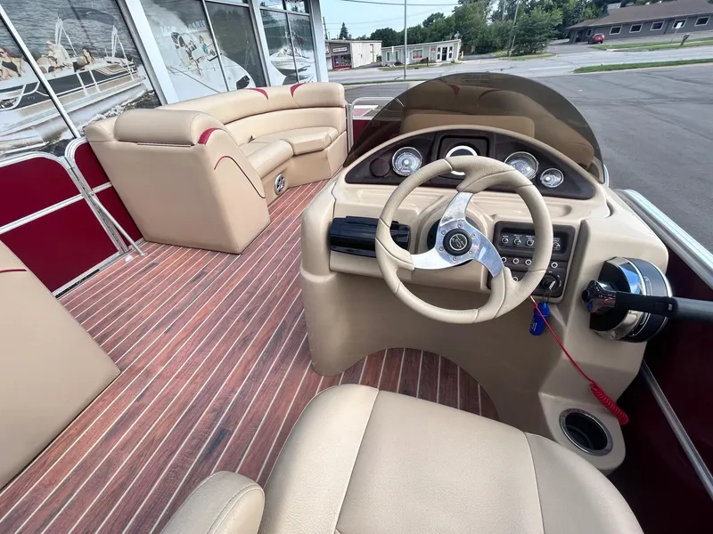 Slide: The Image of Interior of a 2015 Berkshire 210CL CTS pontoon boat with beige seating and wood-like flooring. - 13