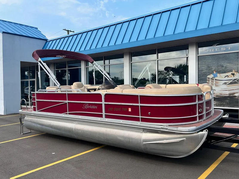 Slide: The Image of 2015 Berkshire 210CL CTS pontoon boat with red exterior parked outside dealership. - 3