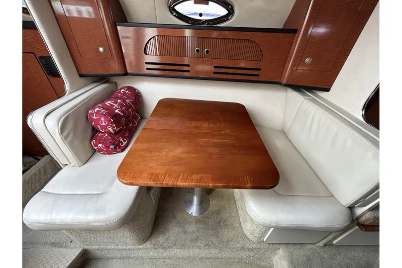 Slide: The Image of 2005 Sea Ray 280 Sundancer cabin with wooden table and white seating. - 12