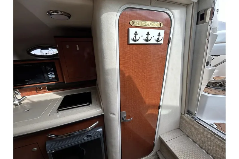 Slide: The Image of Interior of 2005 Sea Ray 280 Sundancer with wooden door and nautical decor. - 15