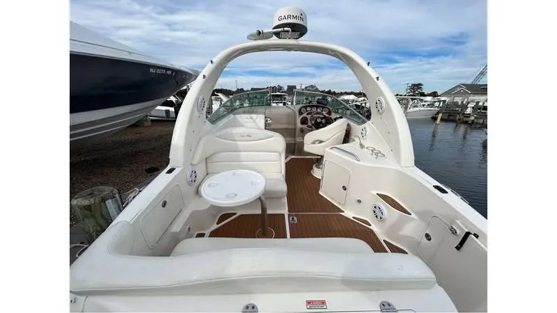 Slide: The Image of 2005 Sea Ray 280 Sundancer boat interior with seating and table, docked at marina. - 2
