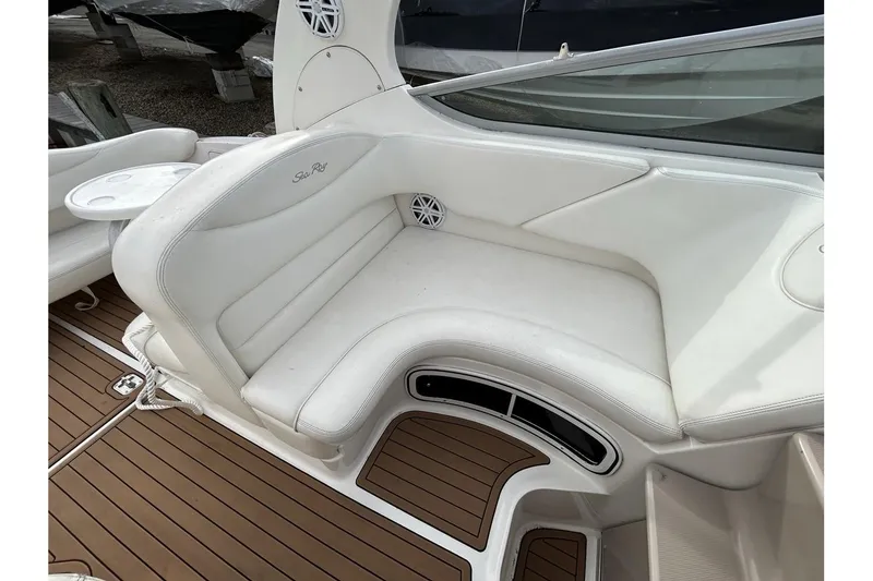 Slide: The Image of 2005 Sea Ray 280 Sundancer boat interior with white seating and wood flooring. - 9