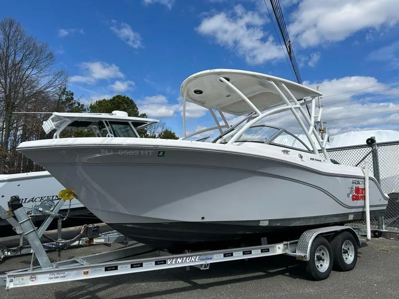 Slide: The Image of 2023 Sea Fox 226 Traveler boat on trailer, parked outdoors under blue sky. - 6