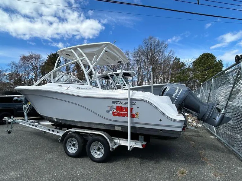 Slide: The Image of 2023 Sea Fox 226 Traveler boat on trailer, parked outdoors under blue sky. - 7
