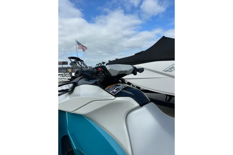 Slide: The Image of 2024 Sea-Doo GTI SE 130 jet ski with American flag in background, under blue sky. - 7