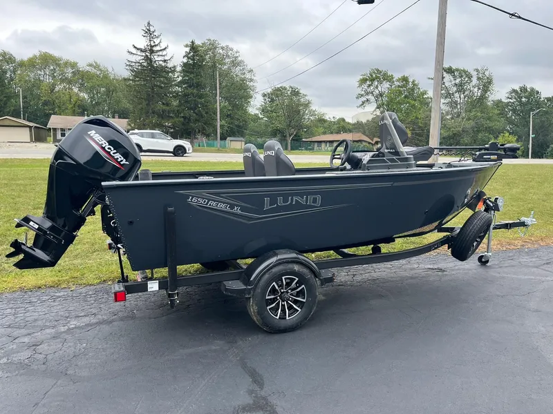 Slide: The Image of 2025 Lund 1650 Rebel XL SS boat on trailer, parked outdoors. - 4