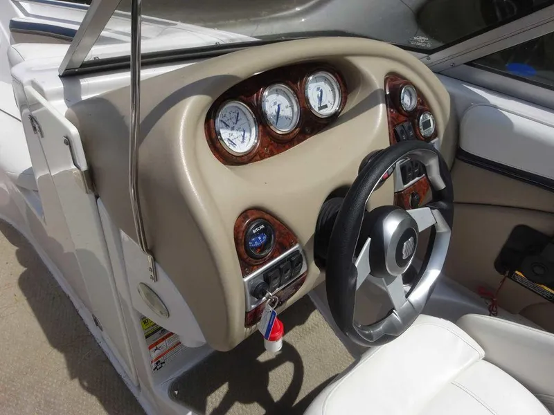 Slide: The Image of 2006 Four Winns H220 boat dashboard with gauges and steering wheel. - 14
