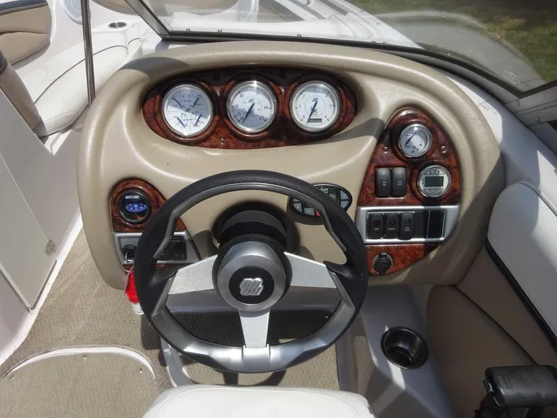 Slide: The Image of 2006 Four Winns H220 boat dashboard with steering wheel and instrument panel. - 16