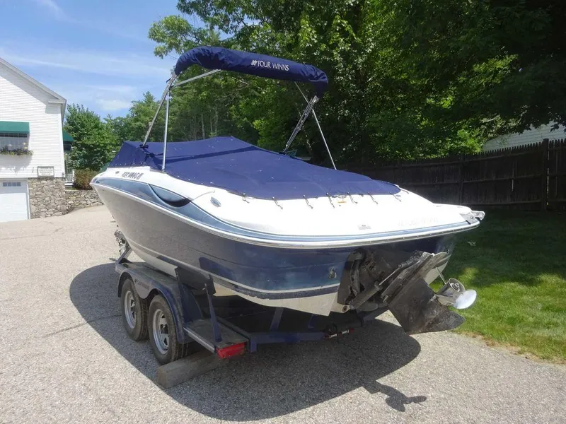 Slide: The Image of 2006 Four Winns H220 boat on trailer, covered and parked outdoors. - 2