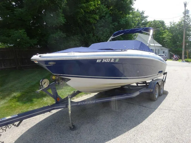 Slide: The Image of 2006 Four Winns H220 boat on trailer, parked on a residential street. - 23