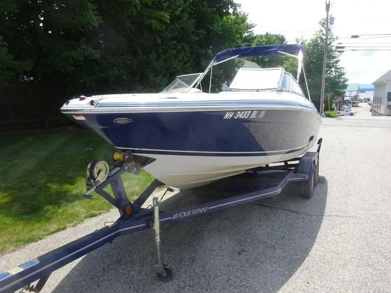 Slide: The Image of 2006 Four Winns H220 boat on trailer, parked on a street. - 4