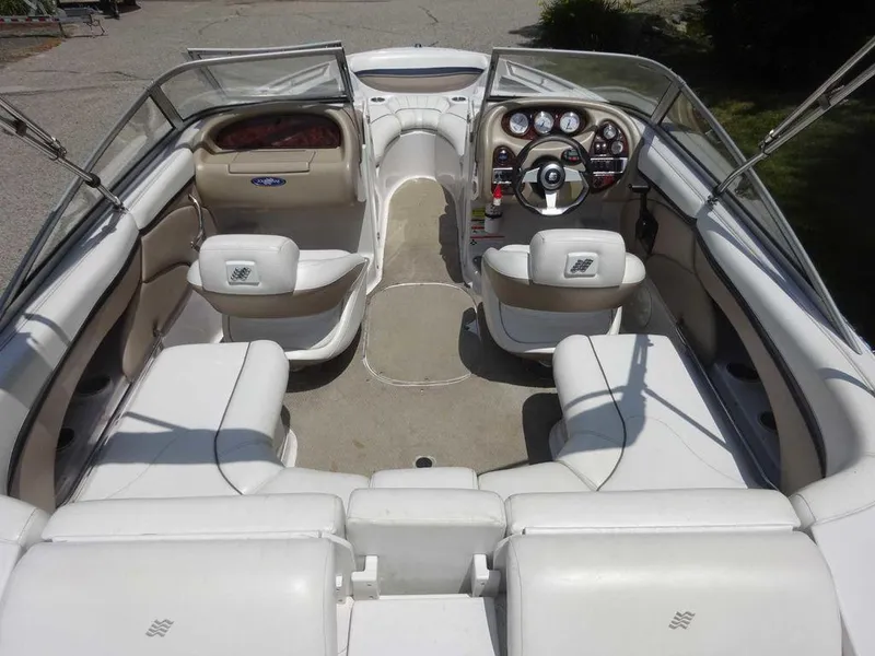 Slide: The Image of 2006 Four Winns H220 boat interior with white seating and dashboard controls. - 7