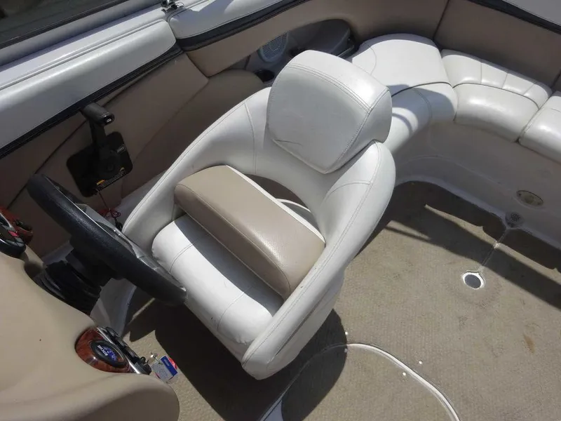 Slide: The Image of 2006 Four Winns H220 boat interior with white seating and steering wheel. - 8
