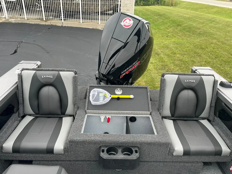 Slide: The Image of 2025 Lund 1875 Tyee boat interior with seats and motor, featuring fishing gear. - 10