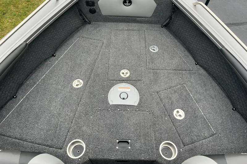 Slide: The Image of 2025 Lund 1875 Tyee boat interior with gray carpeted deck and storage compartments. - 11
