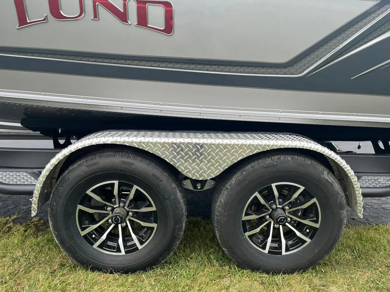 Slide: The Image of 2025 Lund 1875 Tyee trailer with dual wheels on grass. - 24