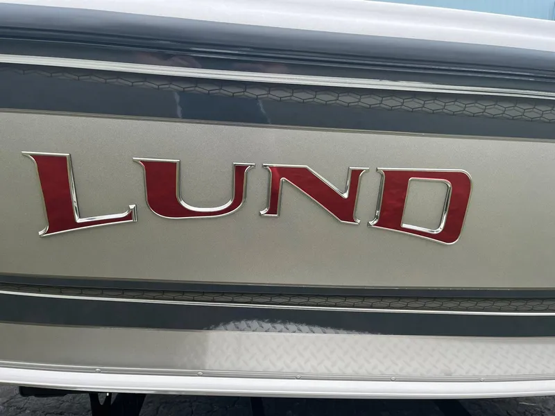 Slide: The Image of 2025 Lund 1875 Tyee boat logo in red on metallic background. - 25