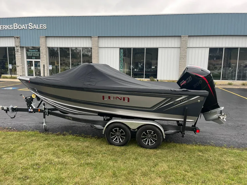 Slide: The Image of 2025 Lund 1875 Tyee boat with cover on trailer outside dealership. - 27