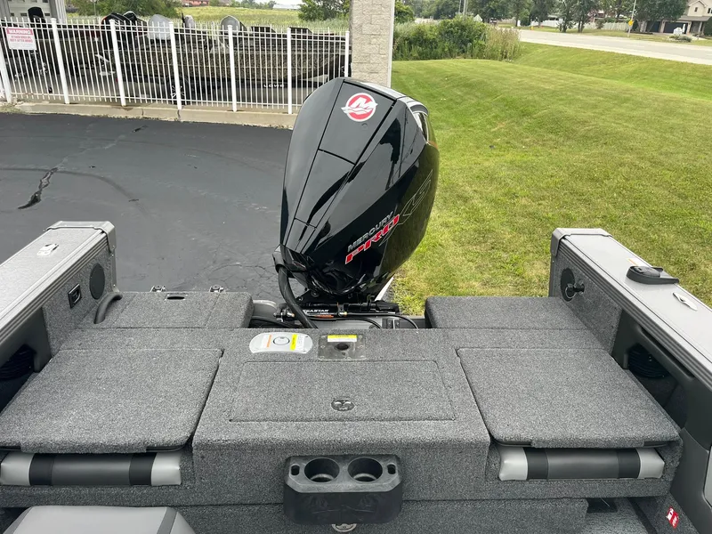 Slide: The Image of 2025 Lund 1875 Tyee boat with powerful outboard motor, parked on pavement. - 9