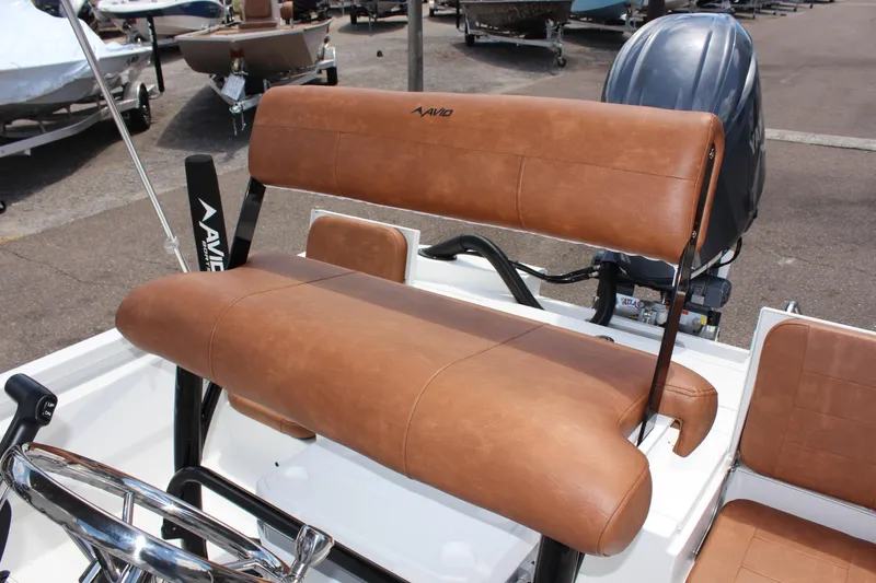 Slide: The Image of 2024 Avid 21 Fusion boat with brown leather seating in a marina. - 11