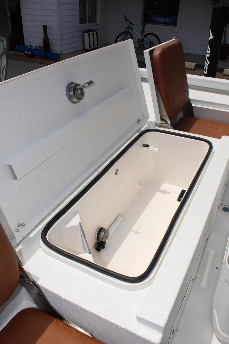 Slide: The Image of 2024 Avid 21 Fusion boat with open storage compartment and brown seats. - 13