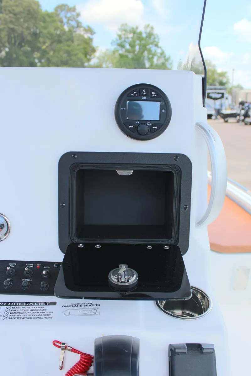 Slide: The Image of 2024 Avid 21 Fusion boat dashboard with open storage compartment and control panel. - 18