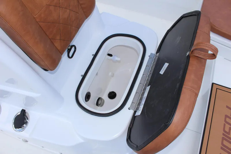 Slide: The Image of Open storage compartment on the 2024 Avid 21 Fusion boat with brown leather seating. - 20