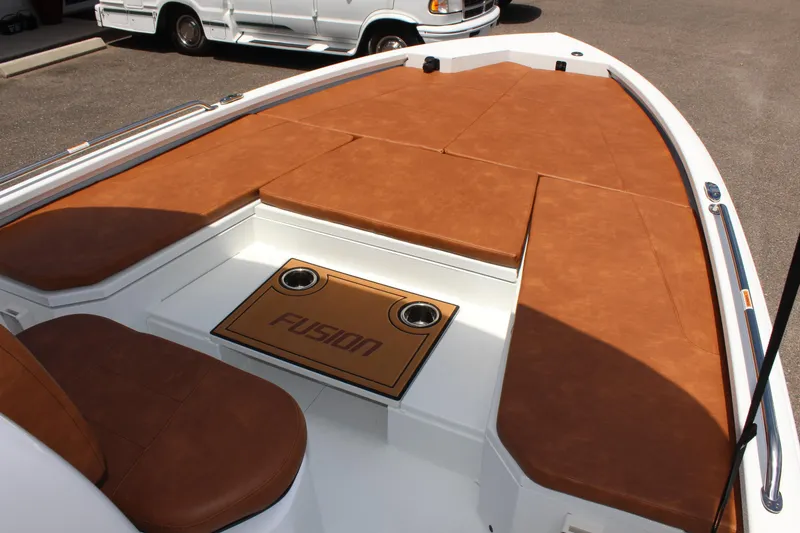 Slide: The Image of 2024 Avid 21 Fusion boat with brown cushioned seating and Fusion branding. - 21